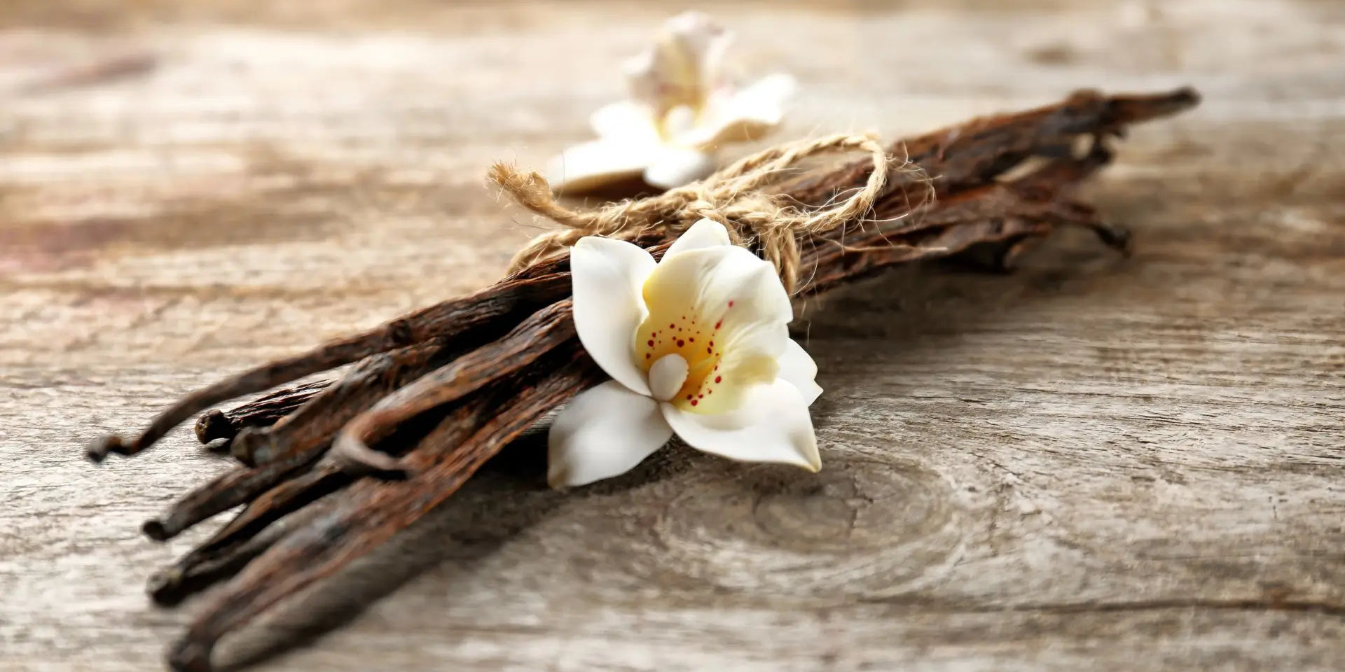 Vanille stokjes en een vanille bloem op een mooie houten tafel