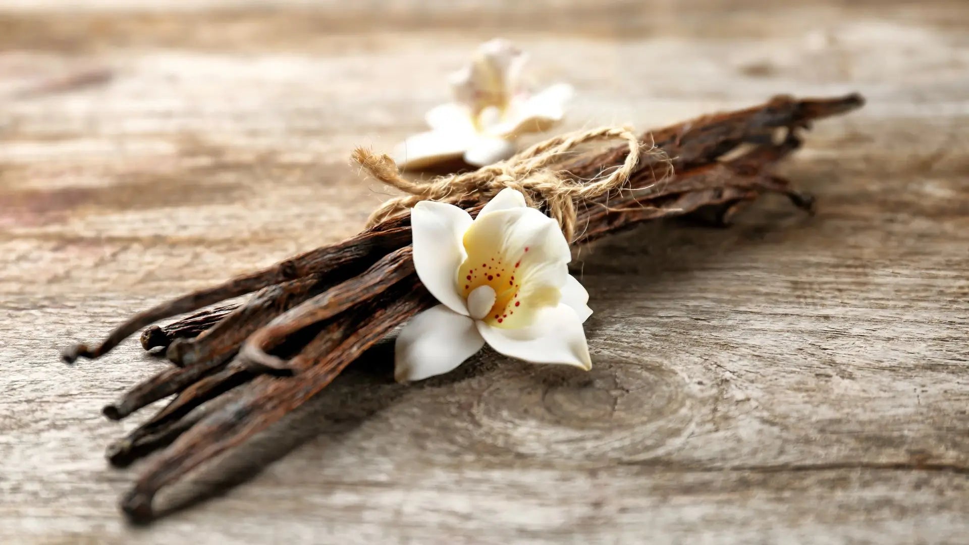 Vanille stokjes en een vanille bloem op een mooie houten tafel
