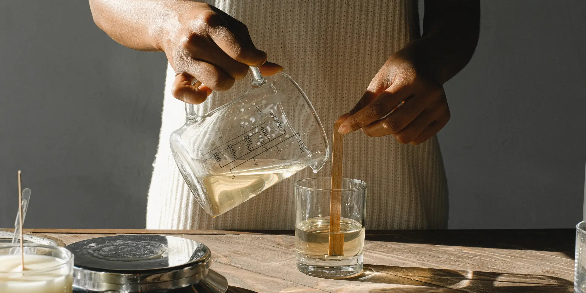 Vrouw die glas vult met honderd procent ecologische zonnebloemwas